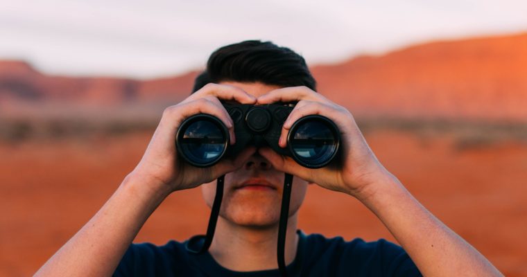 Man with binoculars in desert