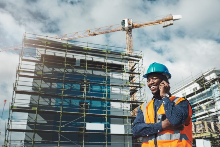 Shot of a young man using a smartphone while working at a construction site.